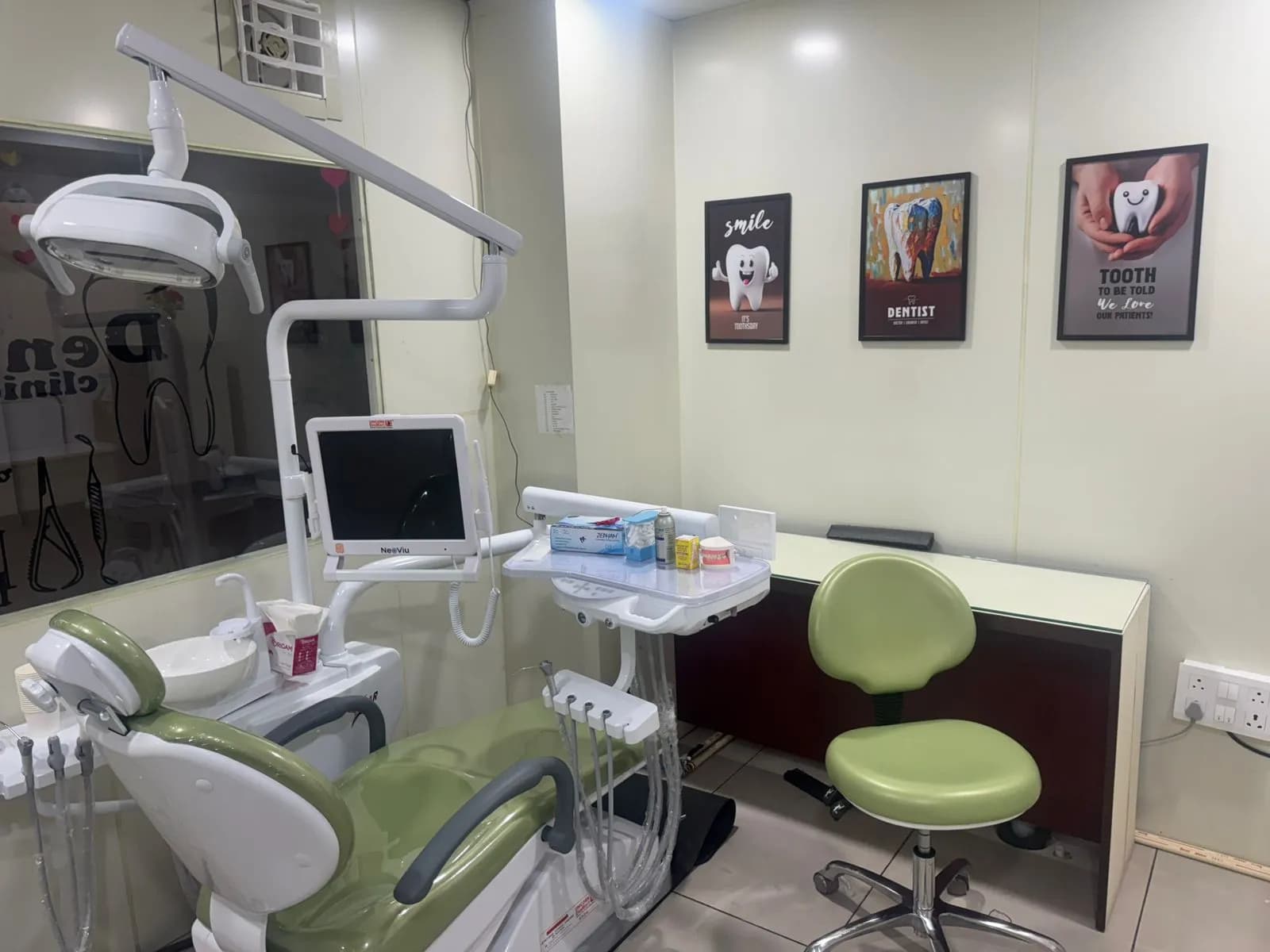 The dental chair under its overhead light, with an intraoral camera screen beside the tray.
