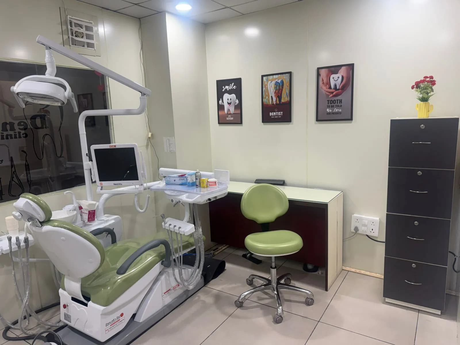 Wider view of the treatment room showing the chair, tray, counter and storage.